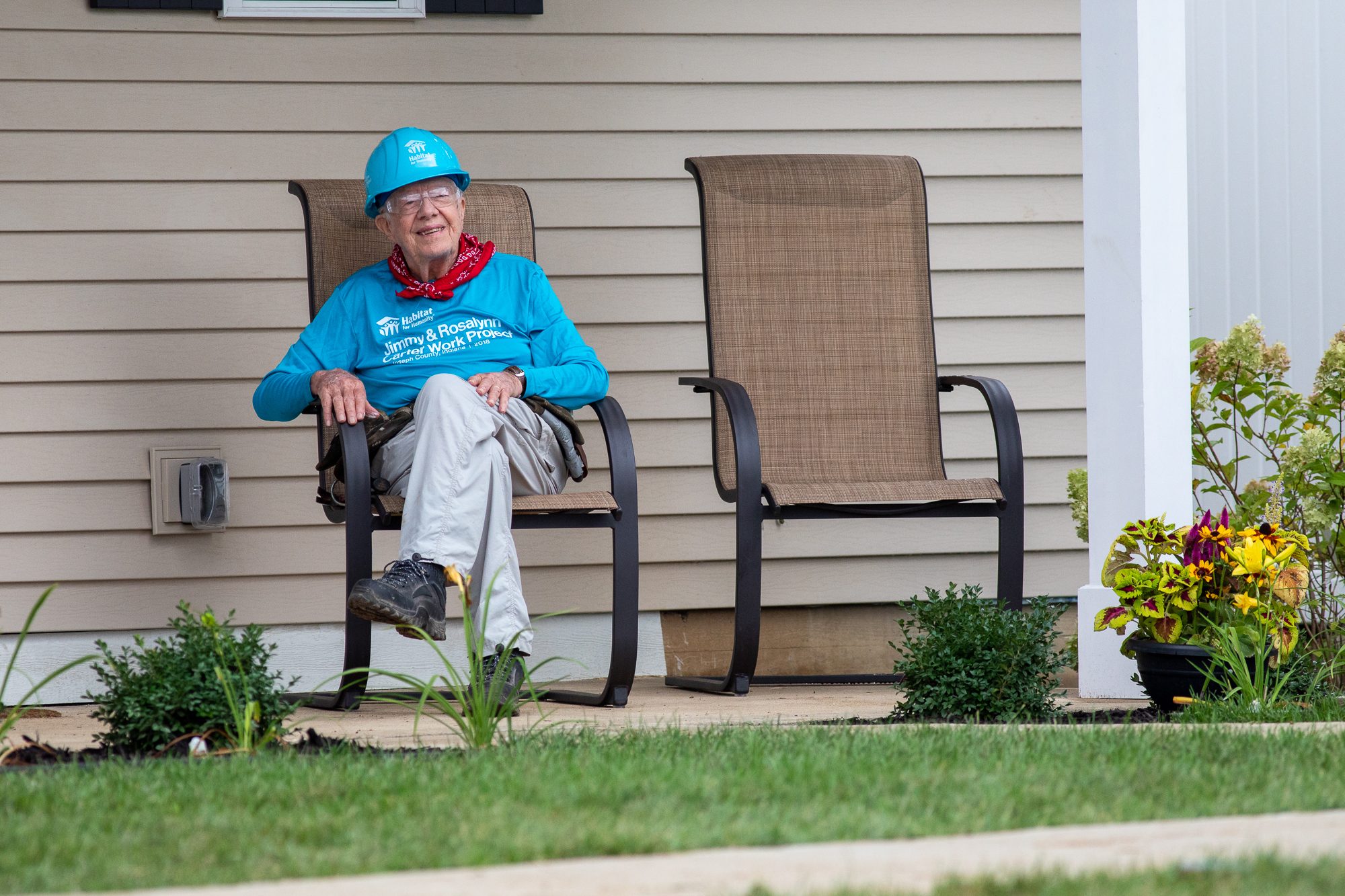 Jimym Carter sitting in an outdoor chair in a construction hat