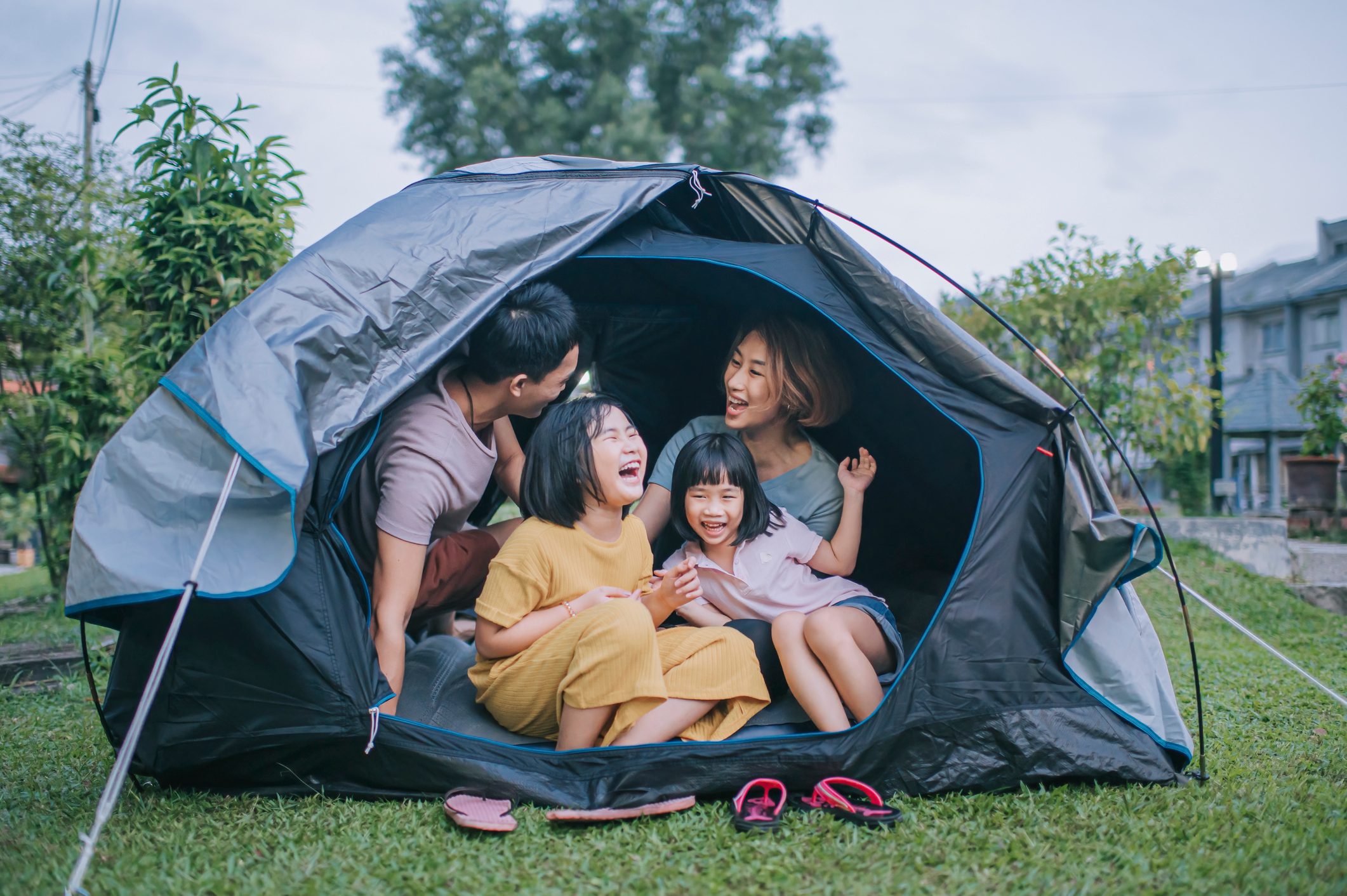 Asian chinese family playing bonding inside camping tent at backyard of their house staycation weekend activities