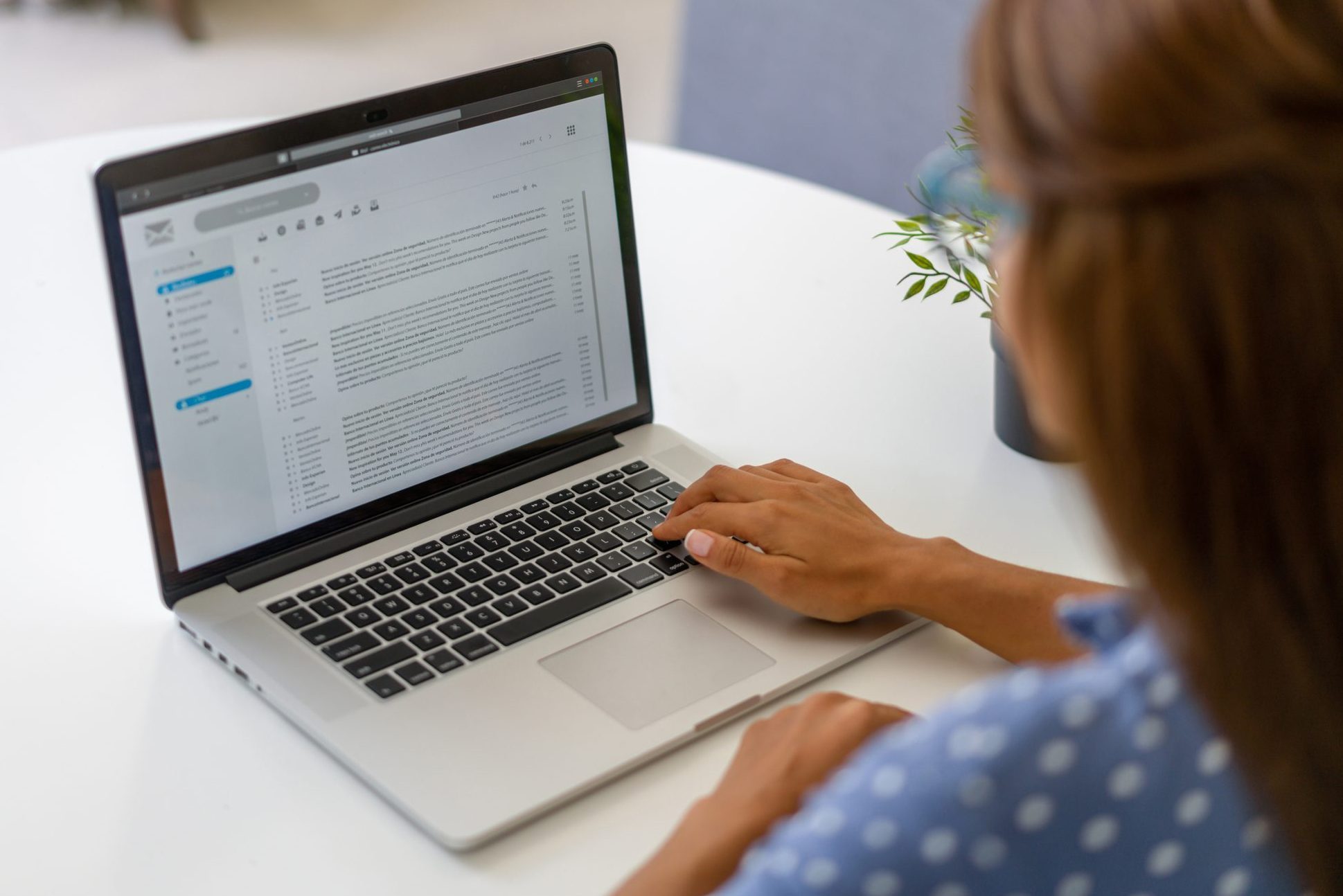 Woman working at home and reading e-mails on her laptop