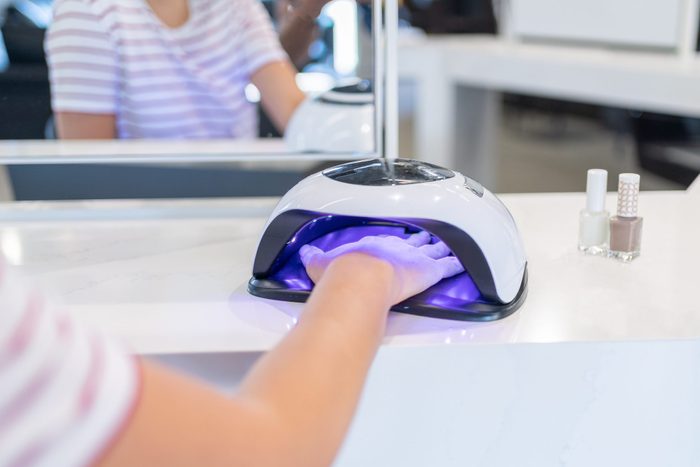 Female Customer Putting Hand İnto UV Lamp Dryer in Beauty Salon