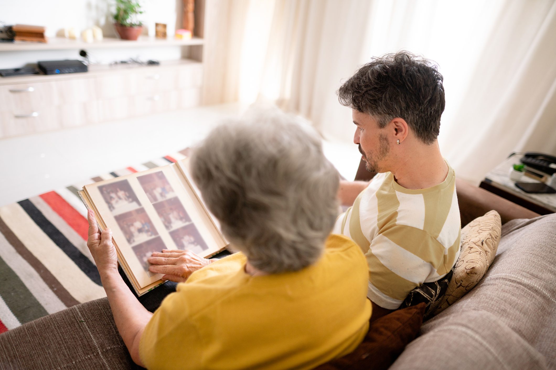 Man and his senior mom looking through family photos together