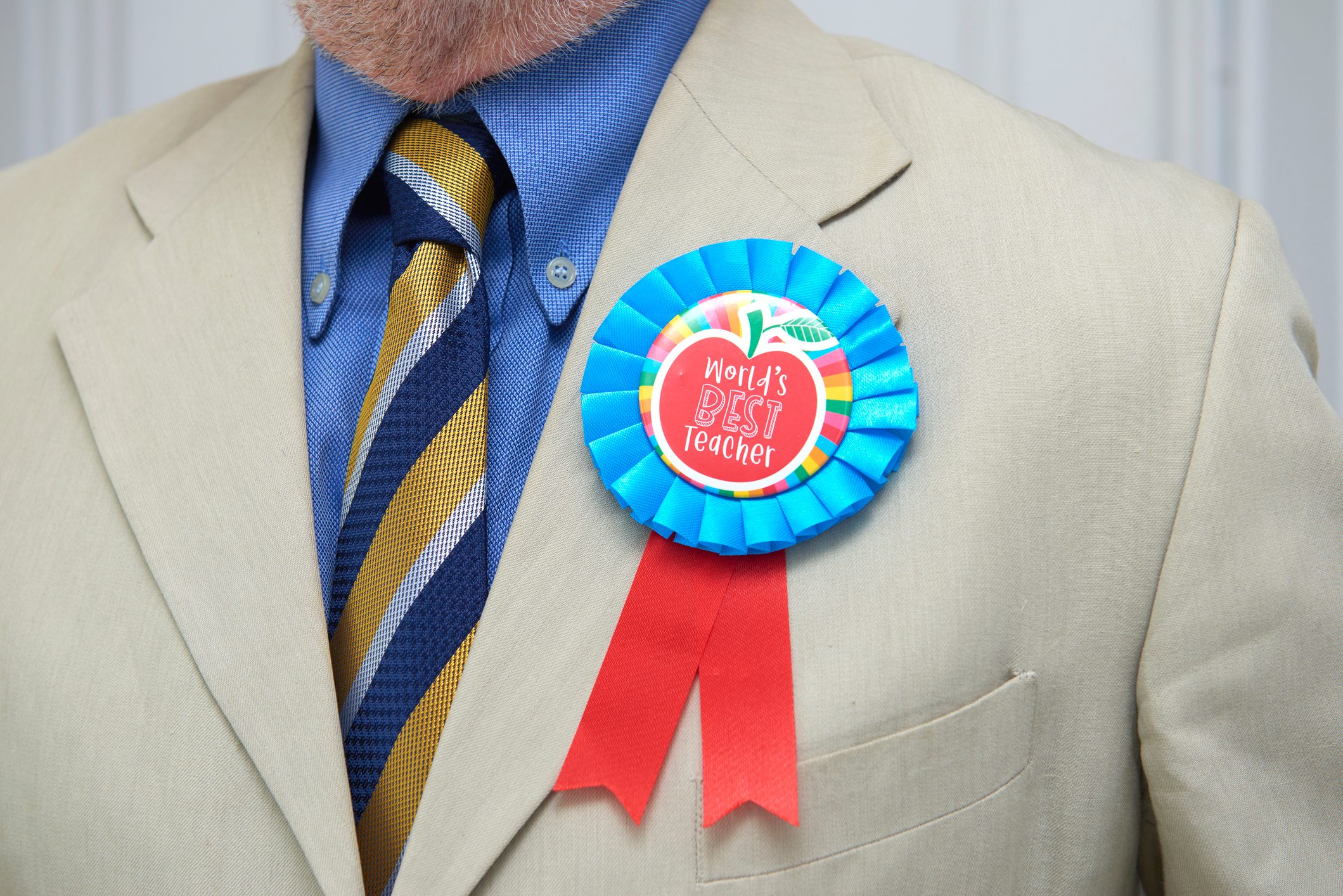 man in a suit wearing a Best teacher award