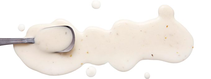 Splashes and spilled ranch dressing with a spoon