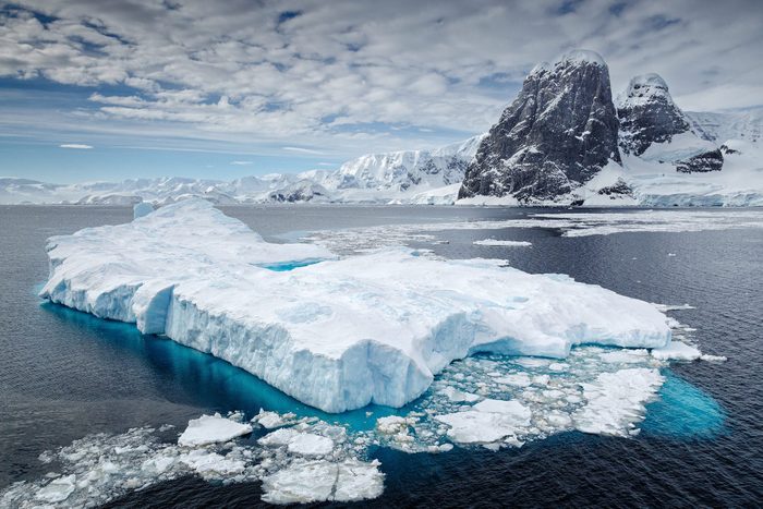Clouds over iceberg floating on water, Antarctica