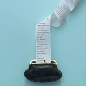 Large receipt coming out of black coin purse on a blue background