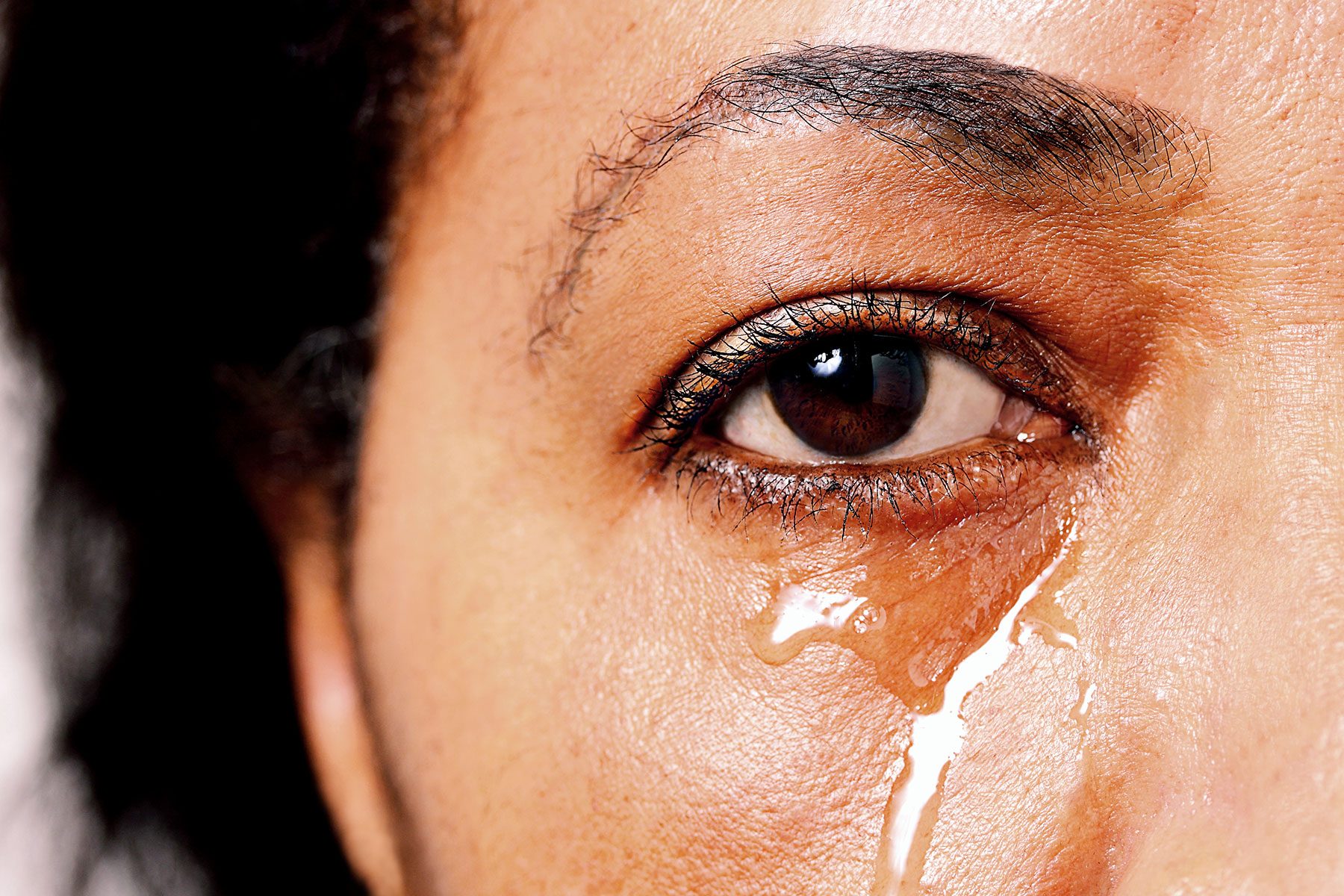 Sad African American female crying with tears rolling down her face