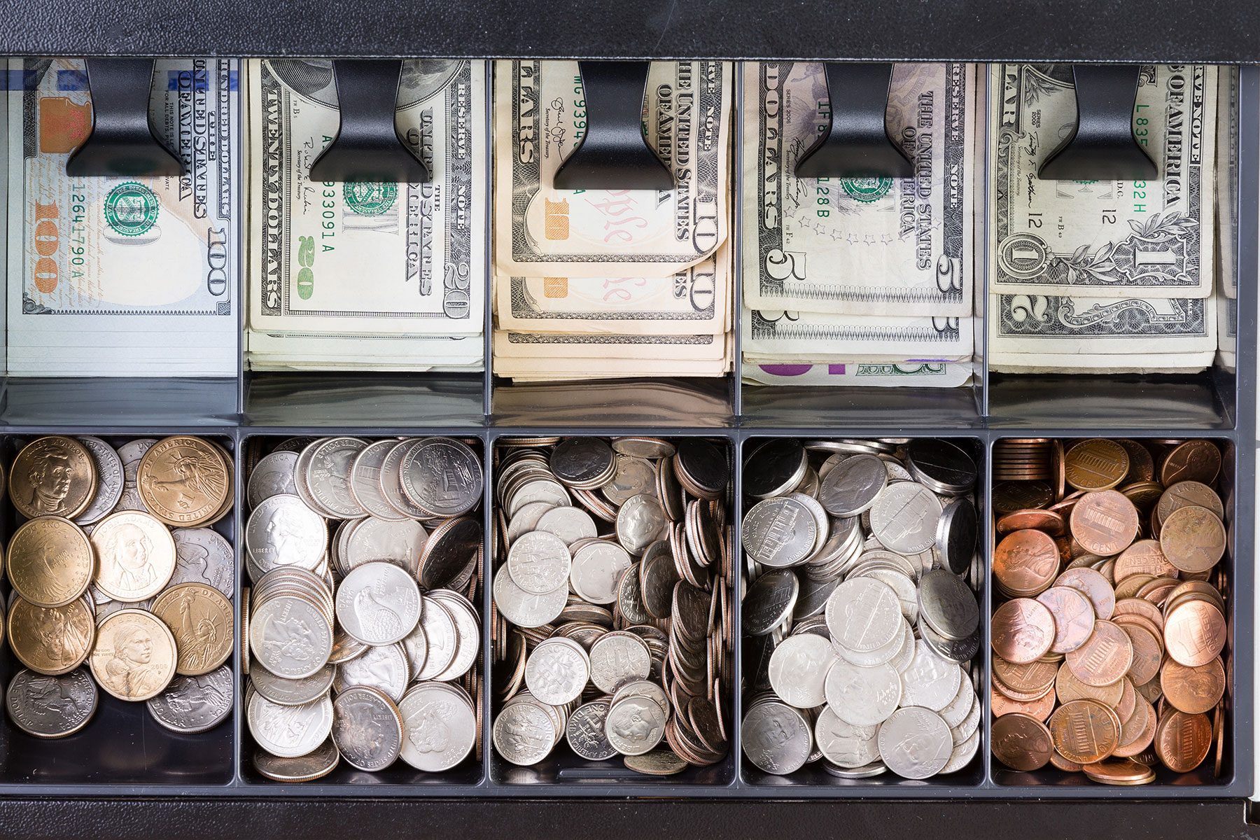 Top View of an Open Cash Register Drawer On Wooden Table