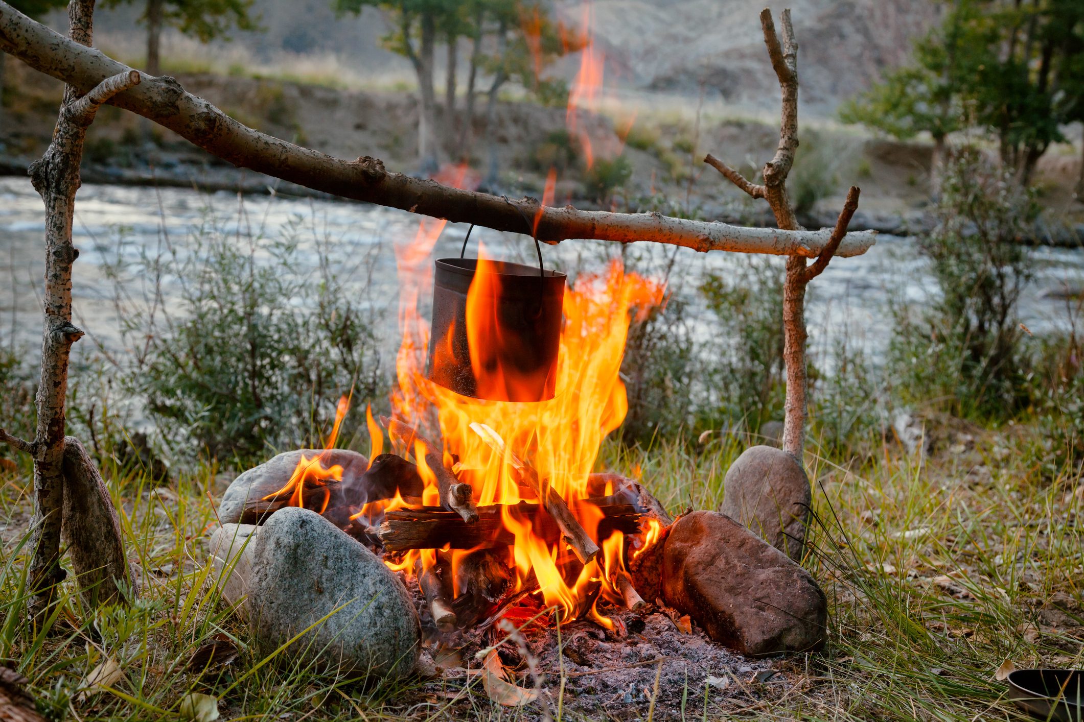 Cooking camp food in cauldron on open fire