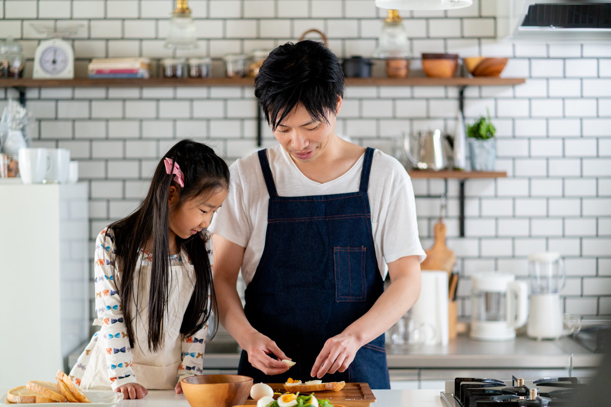 Young father and daughter cooking together at home