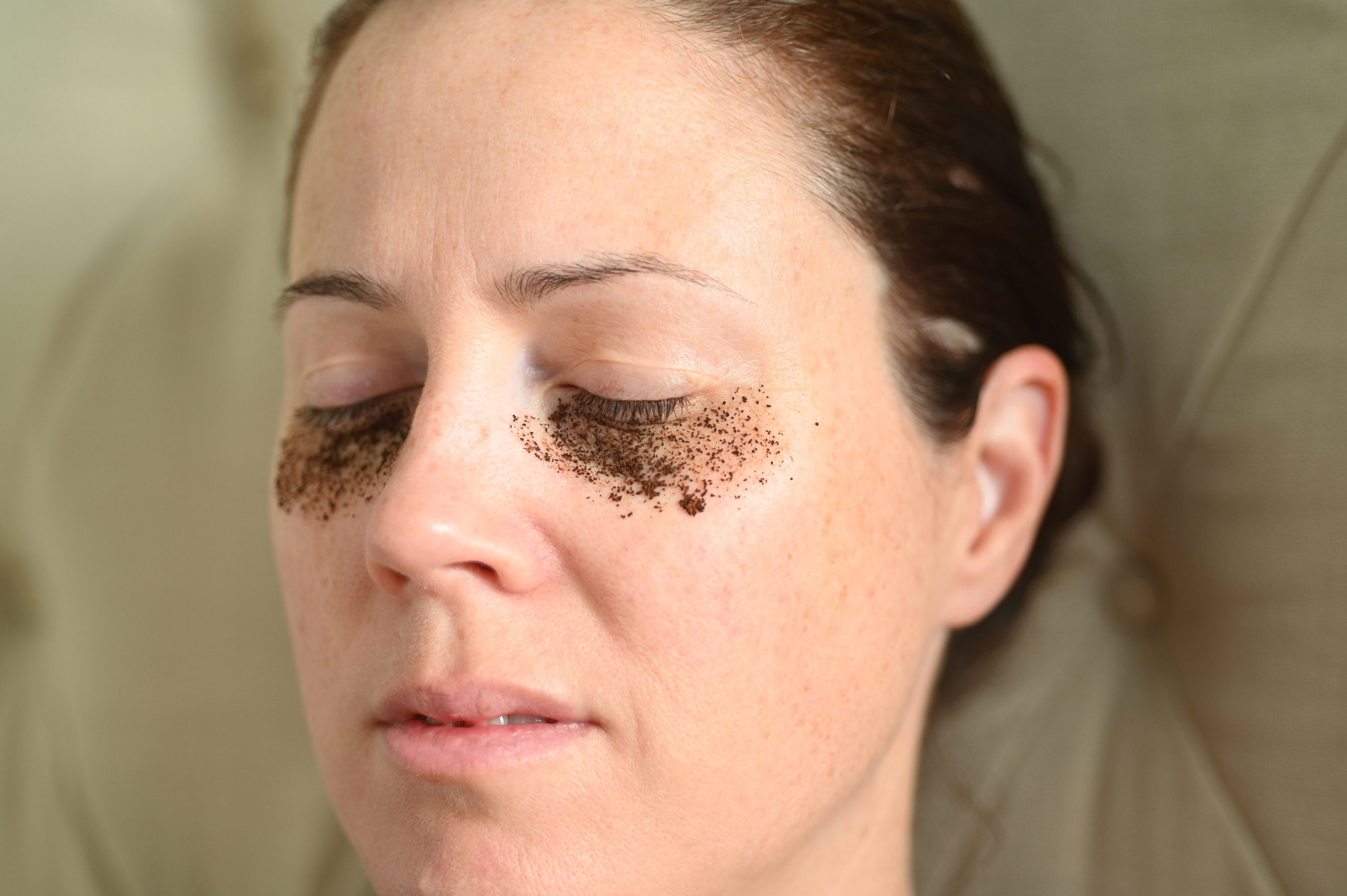 Woman relaxing at home with coffee grounds on her face