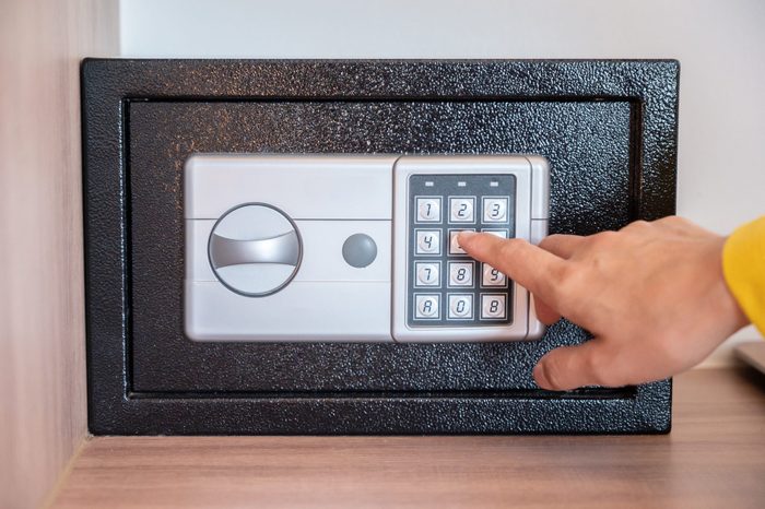 Someone hand trying to press passwords on safety lock pad for open a safety box.