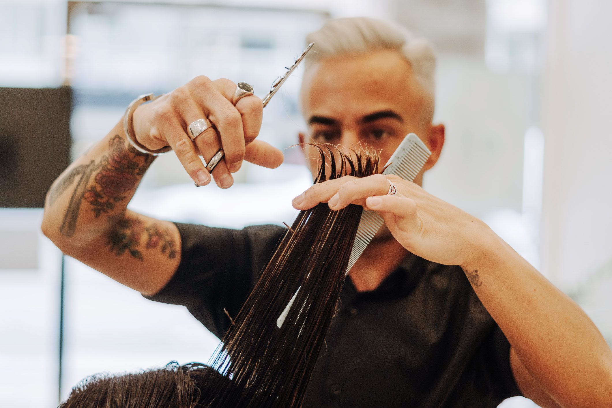 A Handsome Hairstylist Working At The Hairdressing