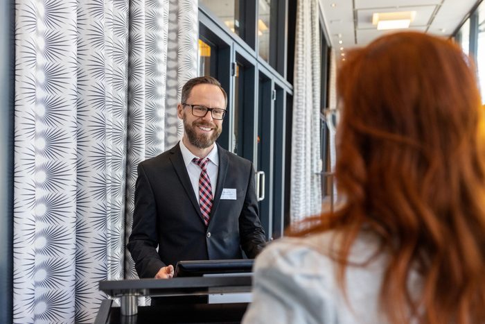 Receptionist assisting a businesswoman at hotel reception desk