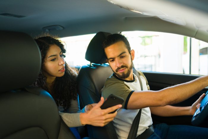 Woman passenger giving directions to the driver