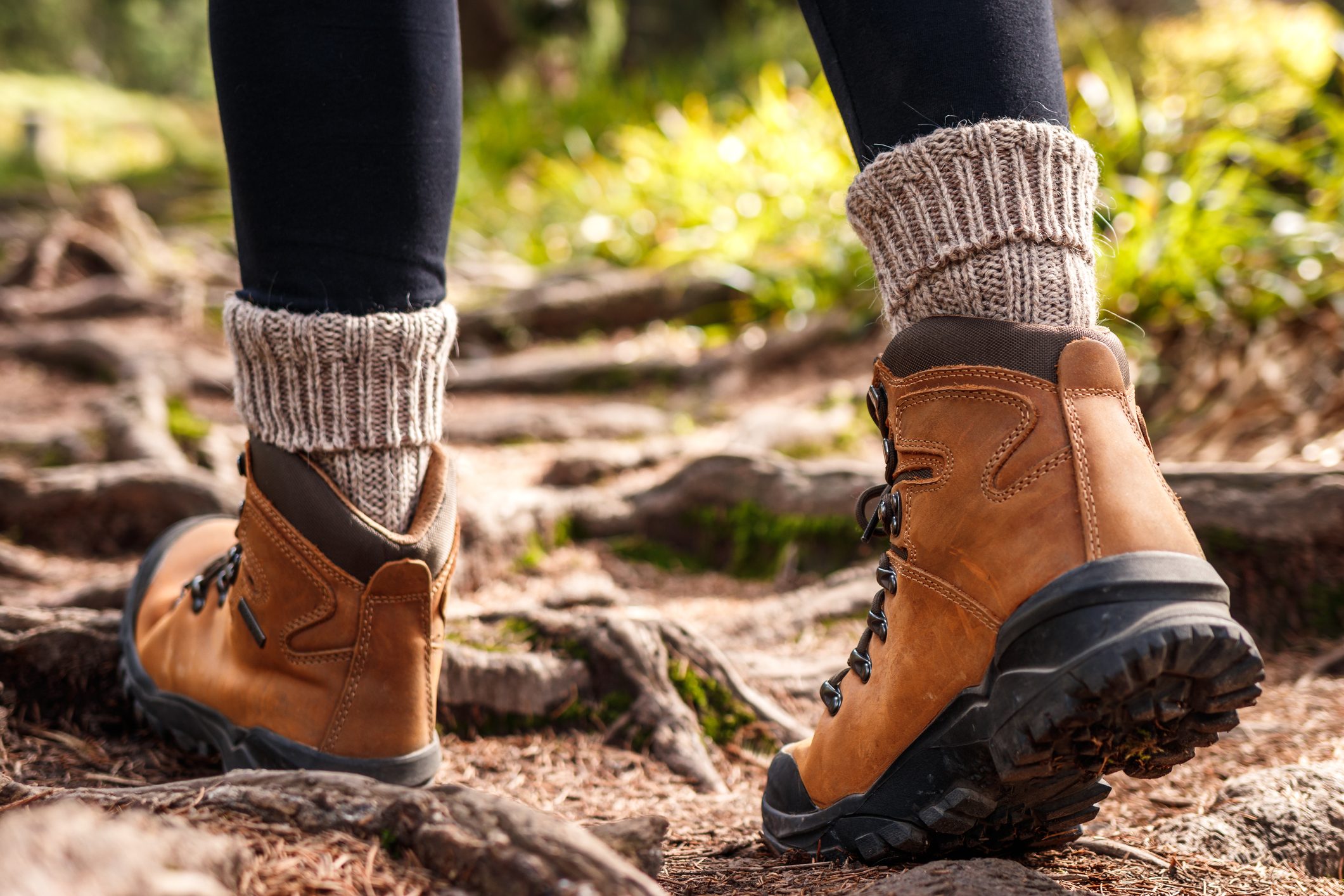 Hiker walking on trekking trail with hiking boots