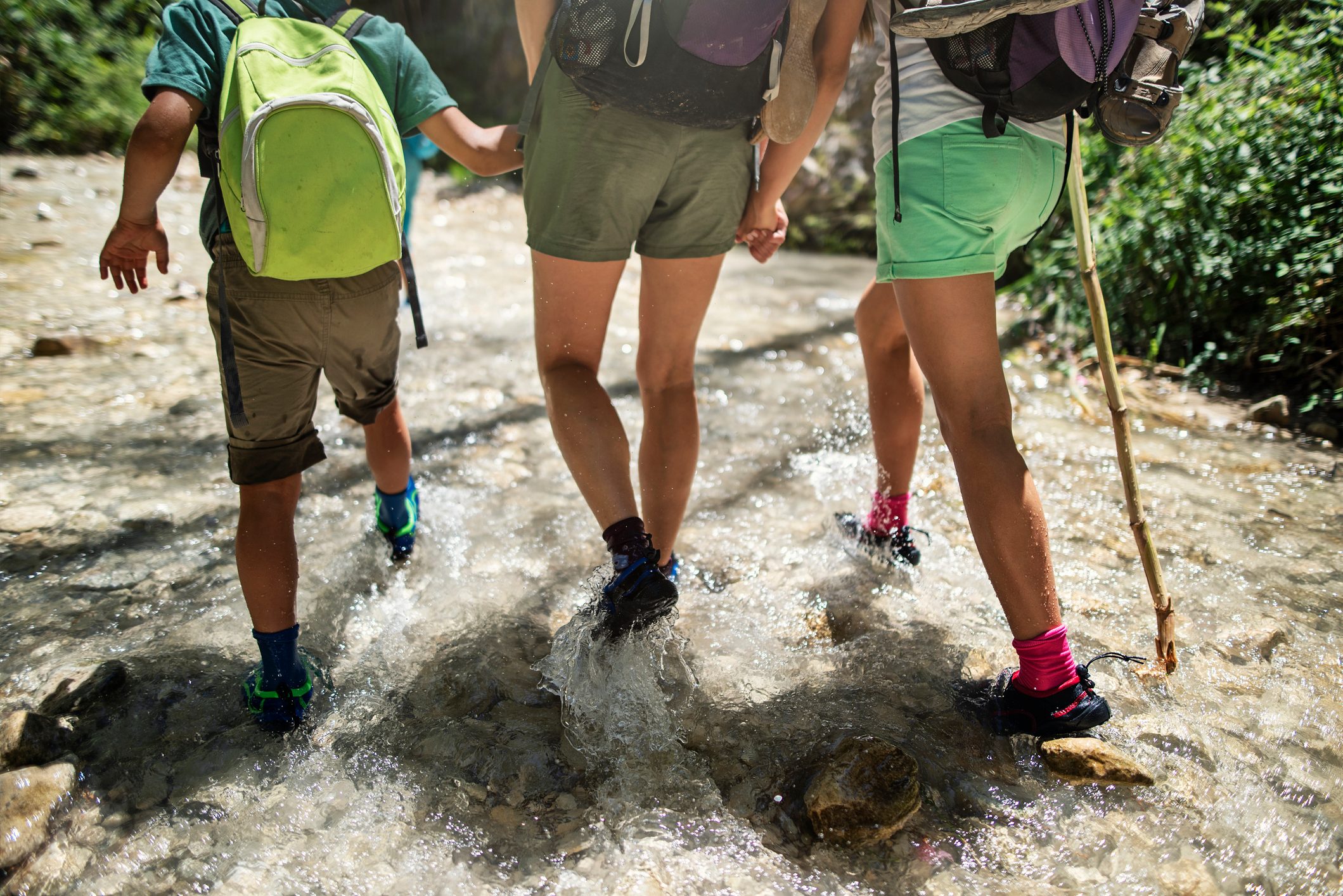 Happy family hiking in a river 