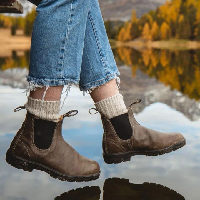 feet with socks and Blundstones sitting near water