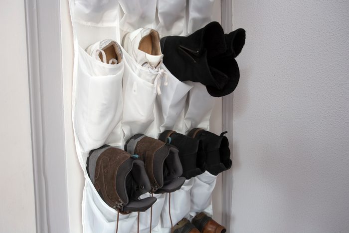 Shoe rack hanging on a wooden door, storage for shoes