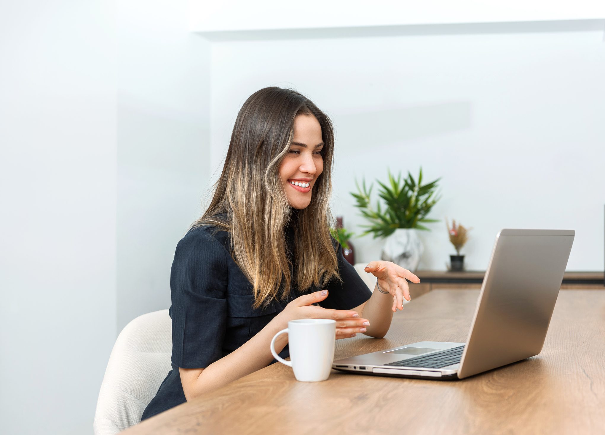 Young and happy woman having video call with laptop at home
