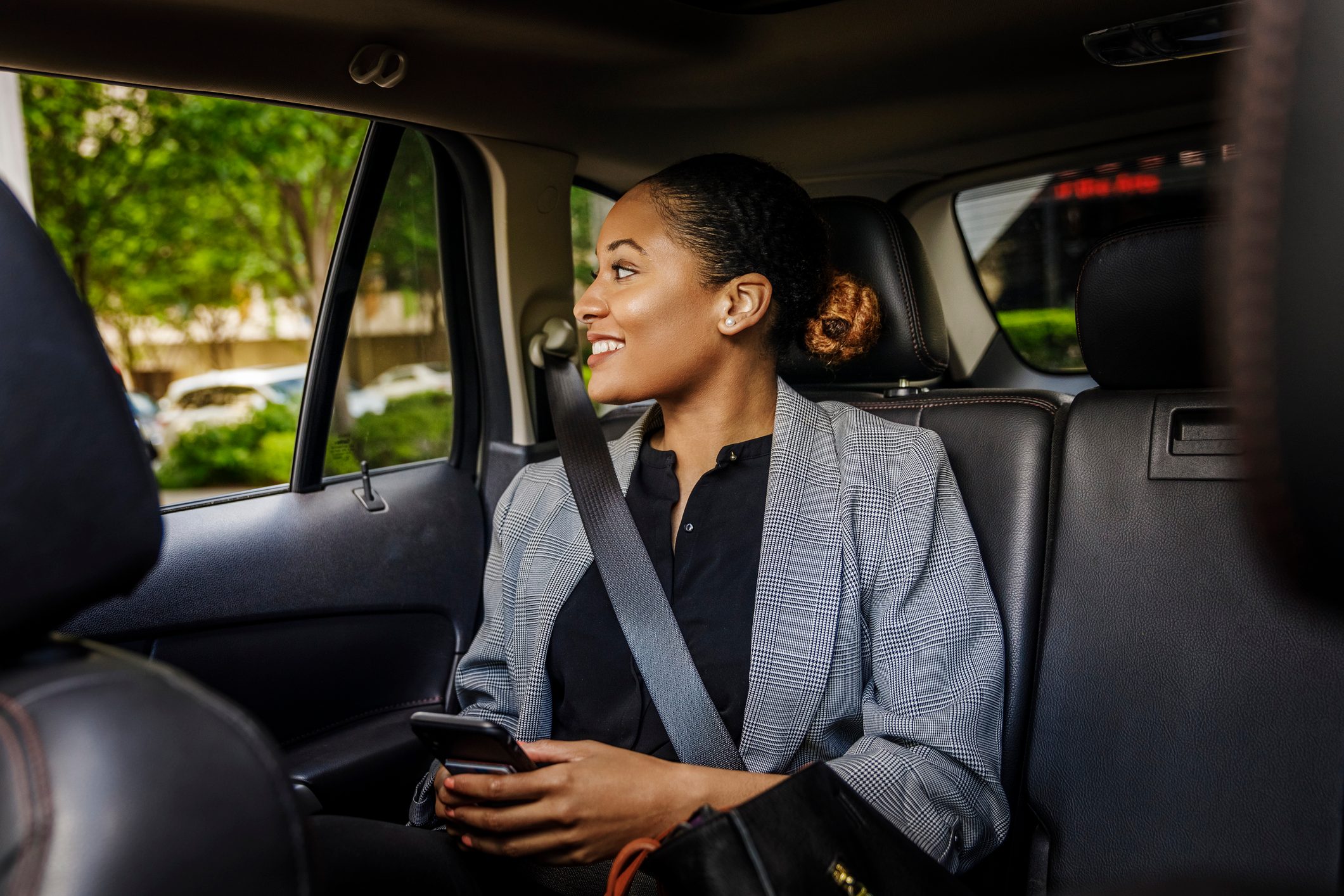 Contemplative businesswoman looking through window sitting in car