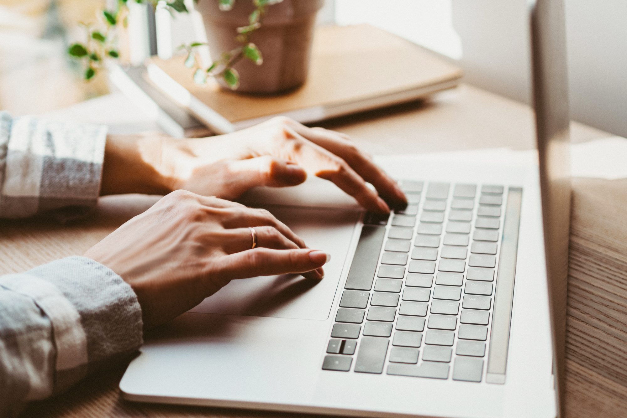 Woman working at home office hand on keyboard close up