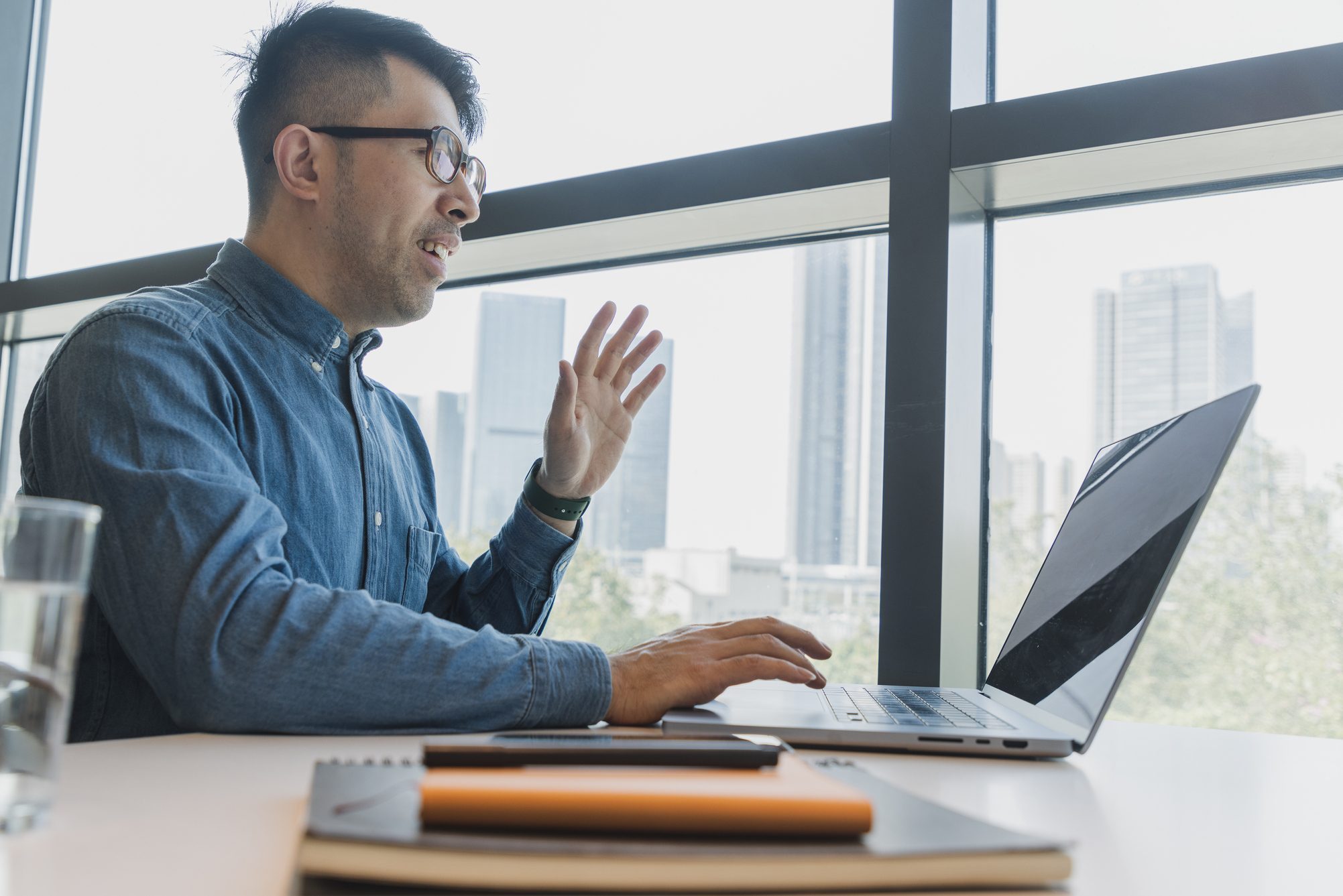 asian man working on a laptop in an office