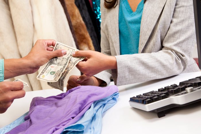 Shopping: Woman buys clothes at local clothing boutique.