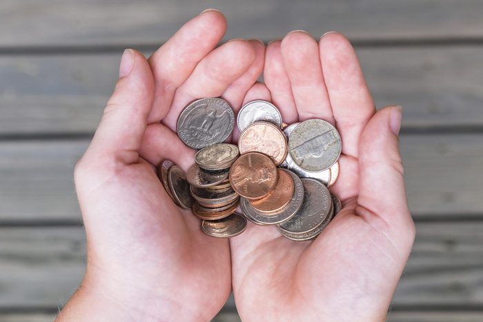 Young boy offers collection of US coins in cupped hands