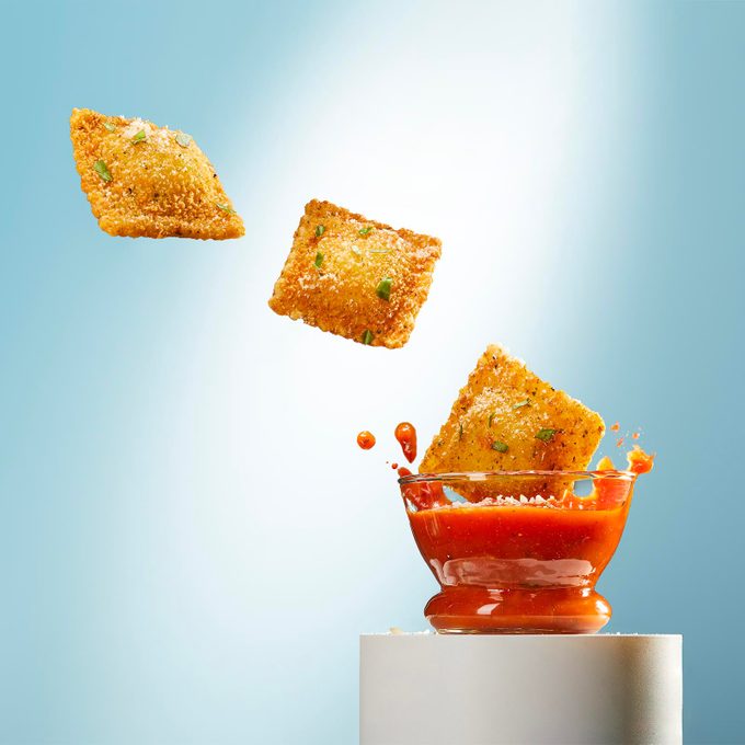 Fried ravioli and tomato sauce on a pedestal