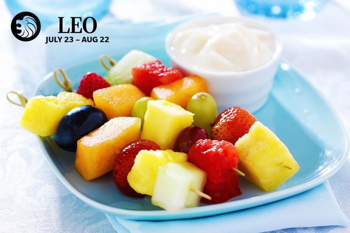 A plate of fruit kebabs and dip