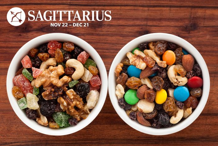 Two bowls of trail mix with nuts, dried fruit, and candy