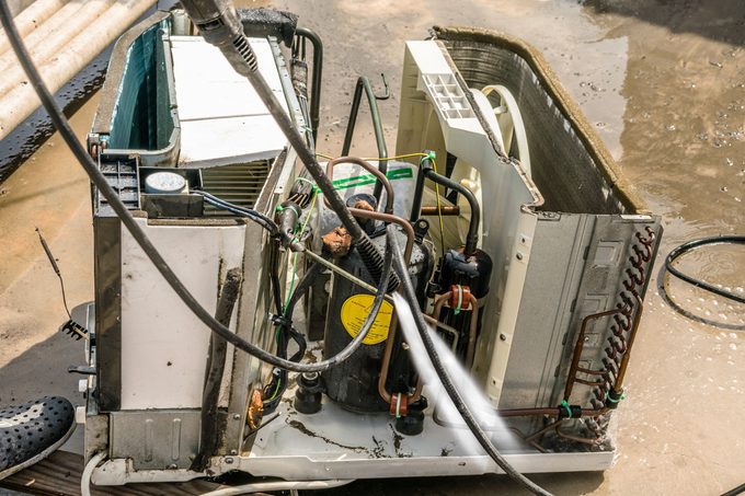 Dusty And Dirty Air Conditioning Cooling System Is Being Sprayed and Cleaning By A Professional Electrician Man