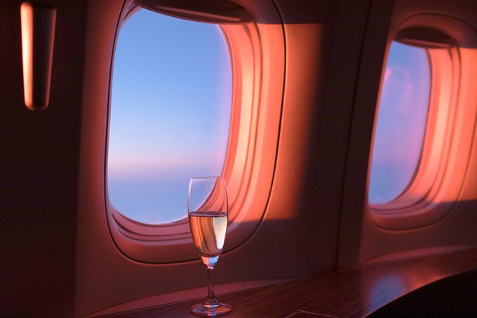 Glass Of Champagne In First Class during sunset in the airplane windows