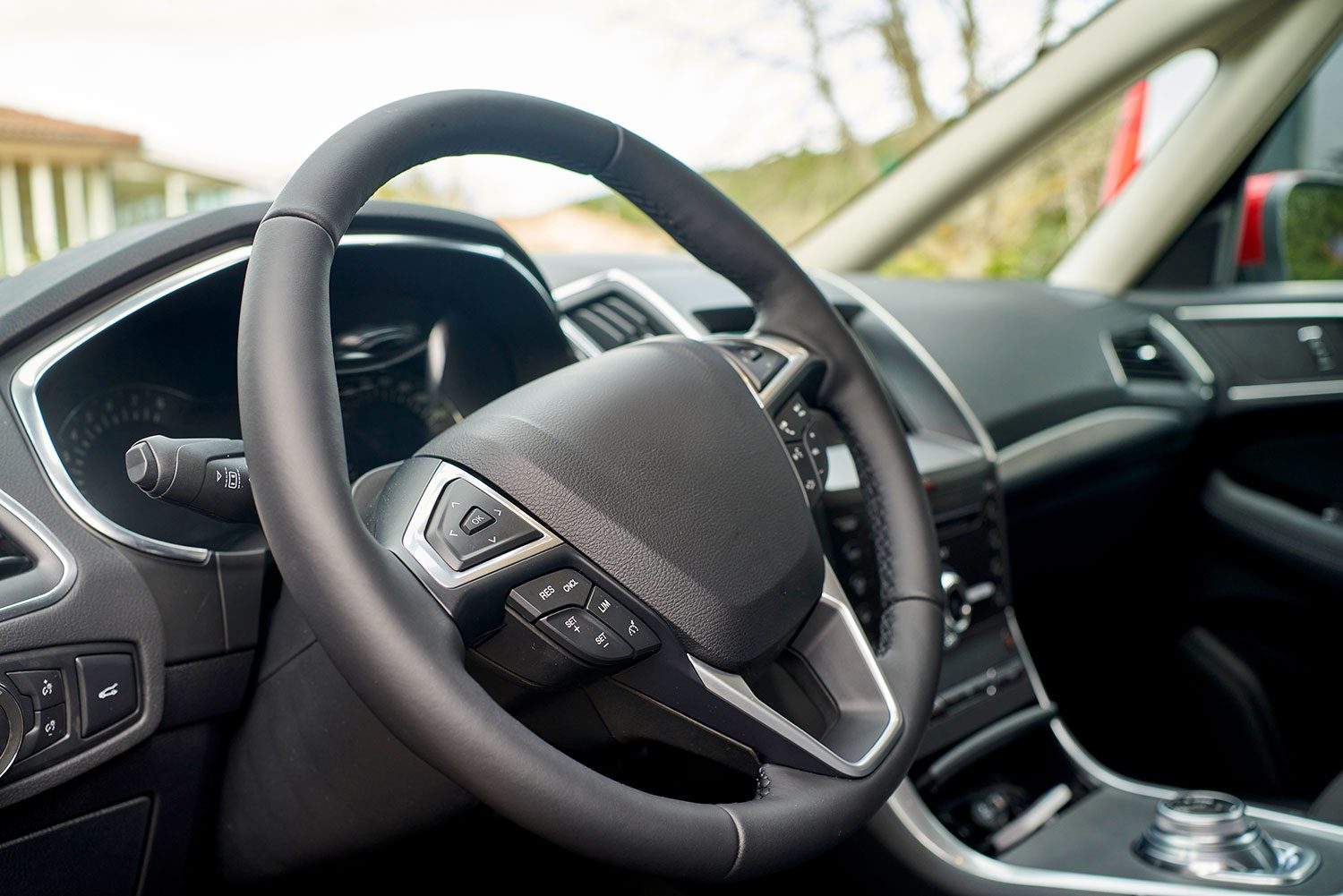 Interior view of a modern automobile parked outside a hotel, buttons and dashboard components