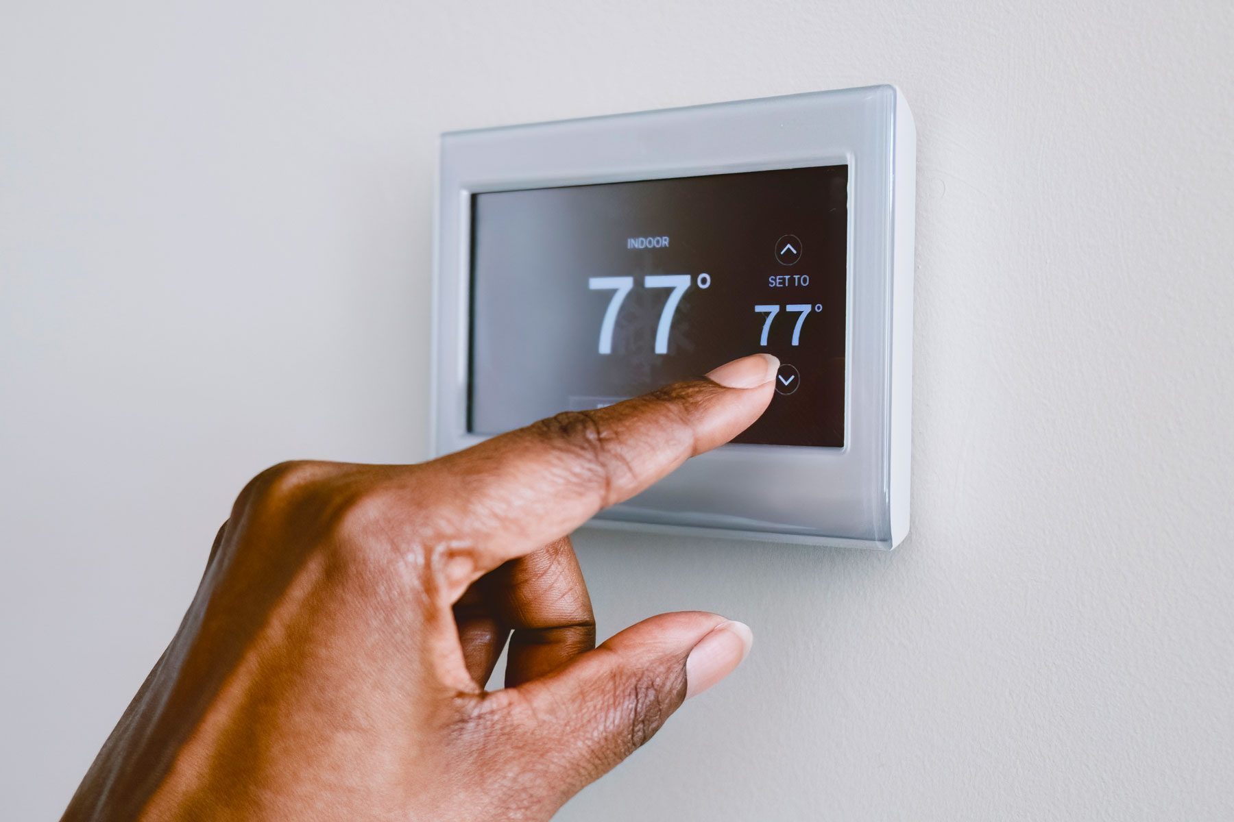 Woman Adjusts Thermostat