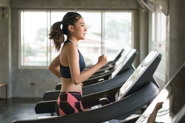Young women in sportswear running on treadmill at gym