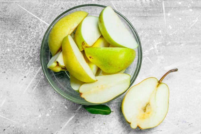 Cut a pear in a glass bowl.