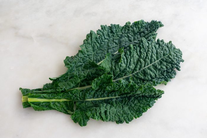 Lacinato Kale Leaves on White Marble Background
