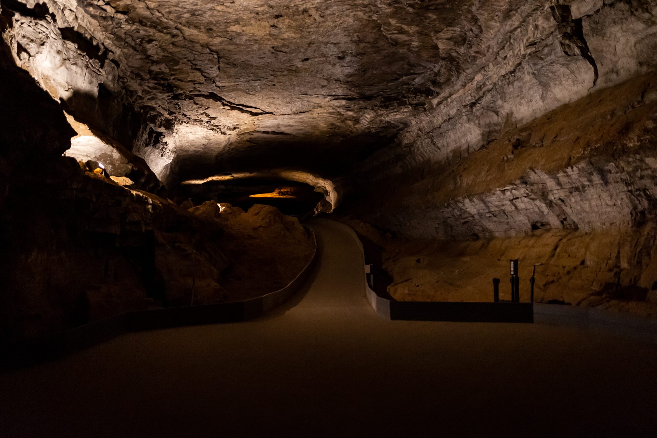 Underground hallway with a paved trail leading to the passages inside Mammoth cave in Kentucky