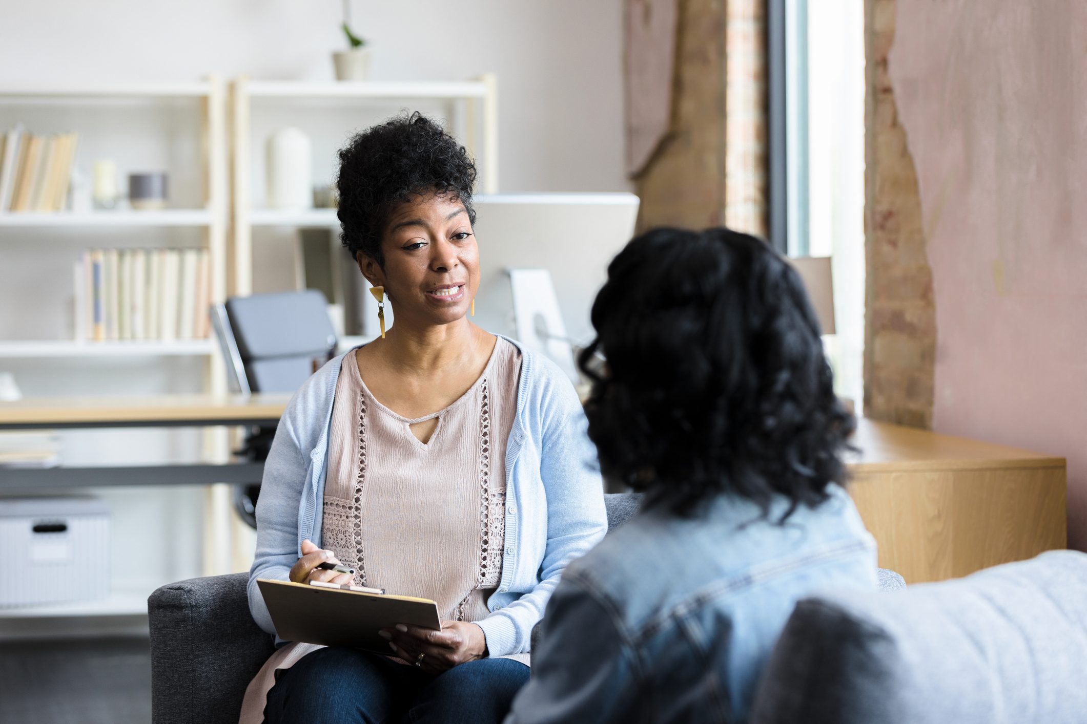 Mature female counselor gives unrecognizable young woman advice