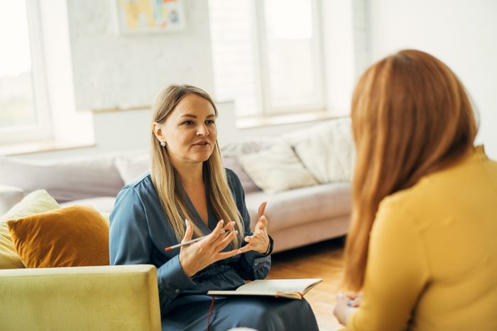 Two women in armchairs are sitting and talking