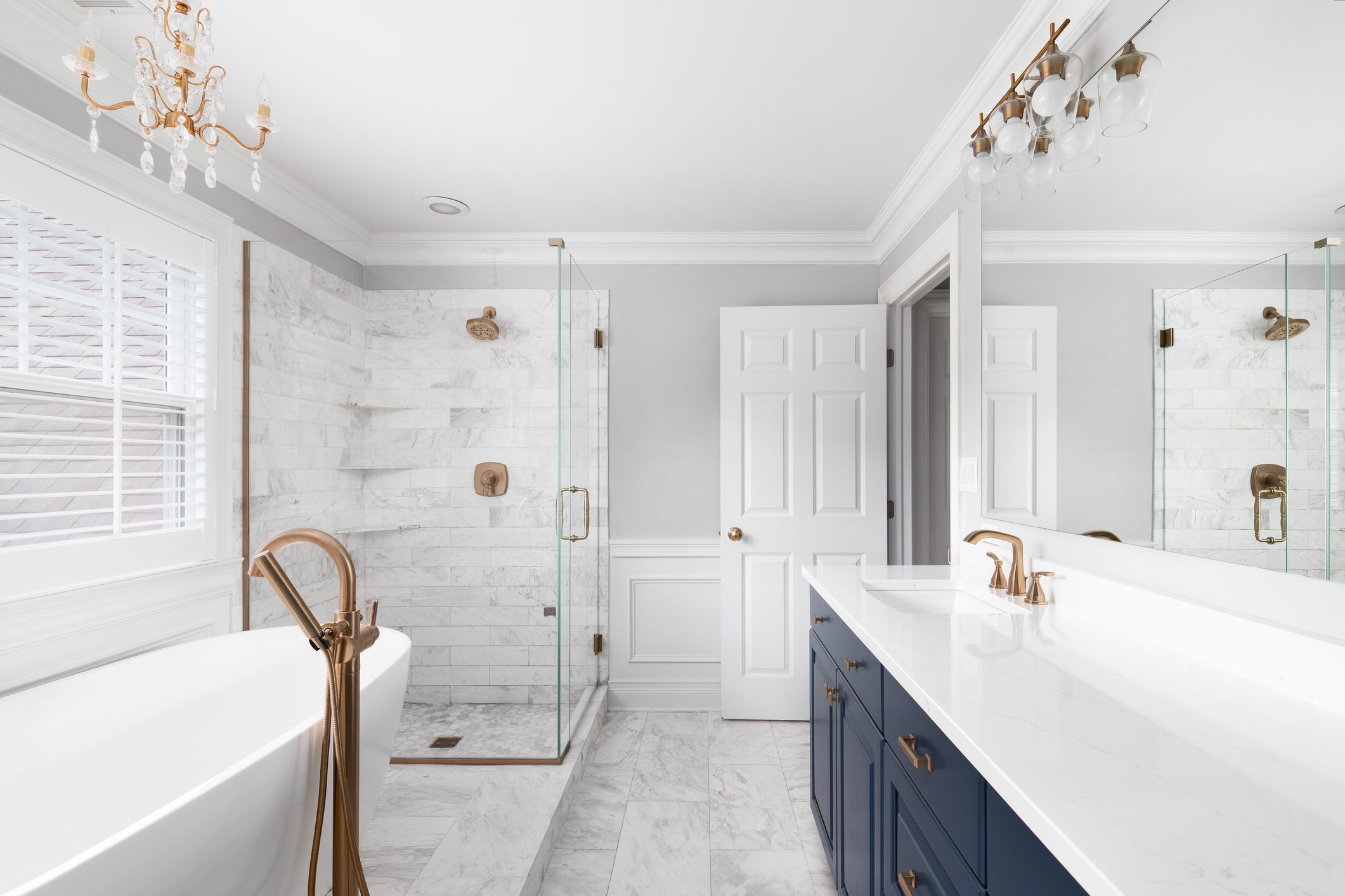 A bathroom with a blue cabinet, bathtub and tiled shower.