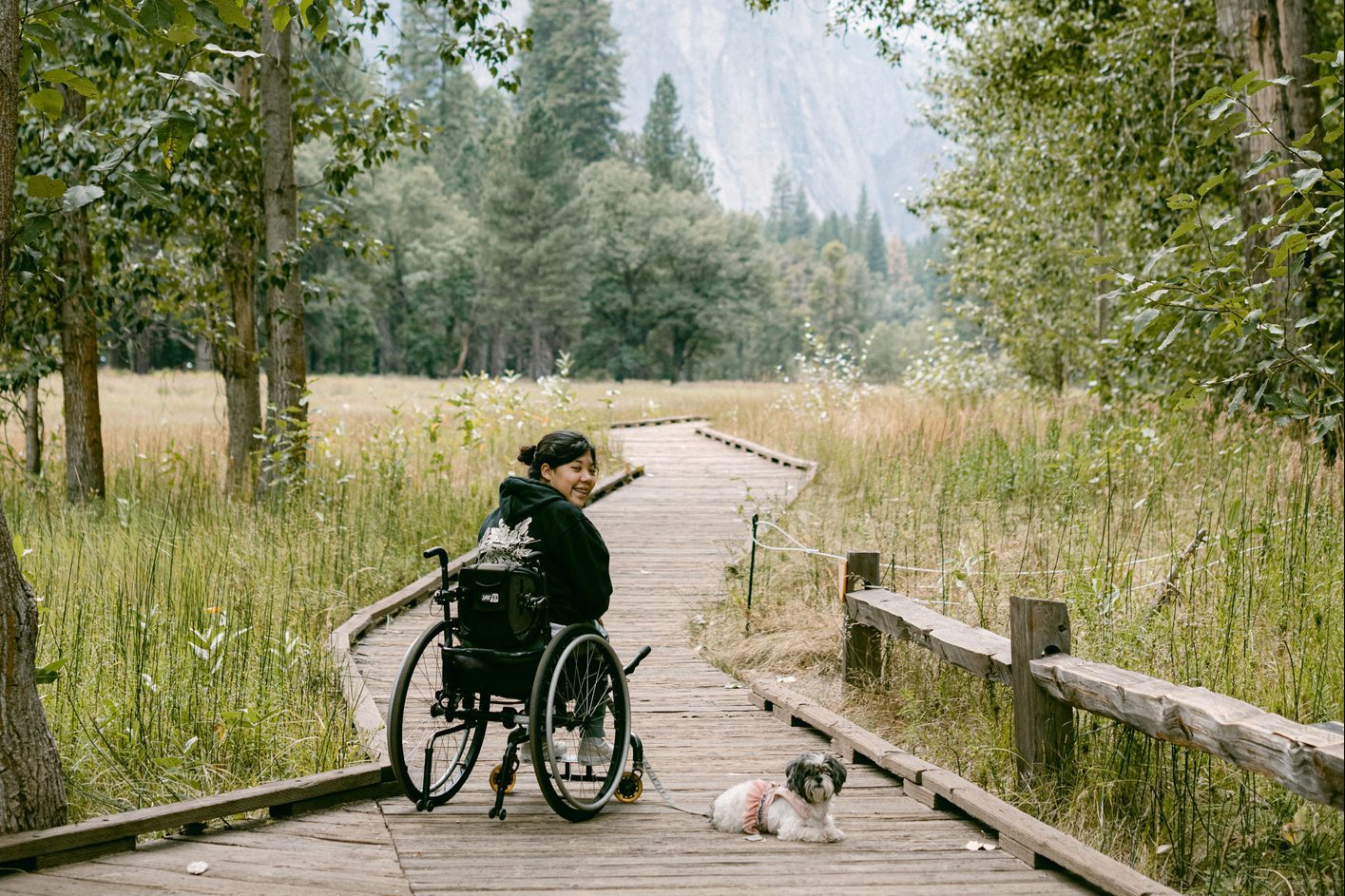 female in wheelchair traveling through Yosemite with dog