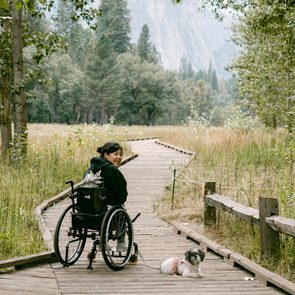 female in wheelchair traveling through Yosemite with dog