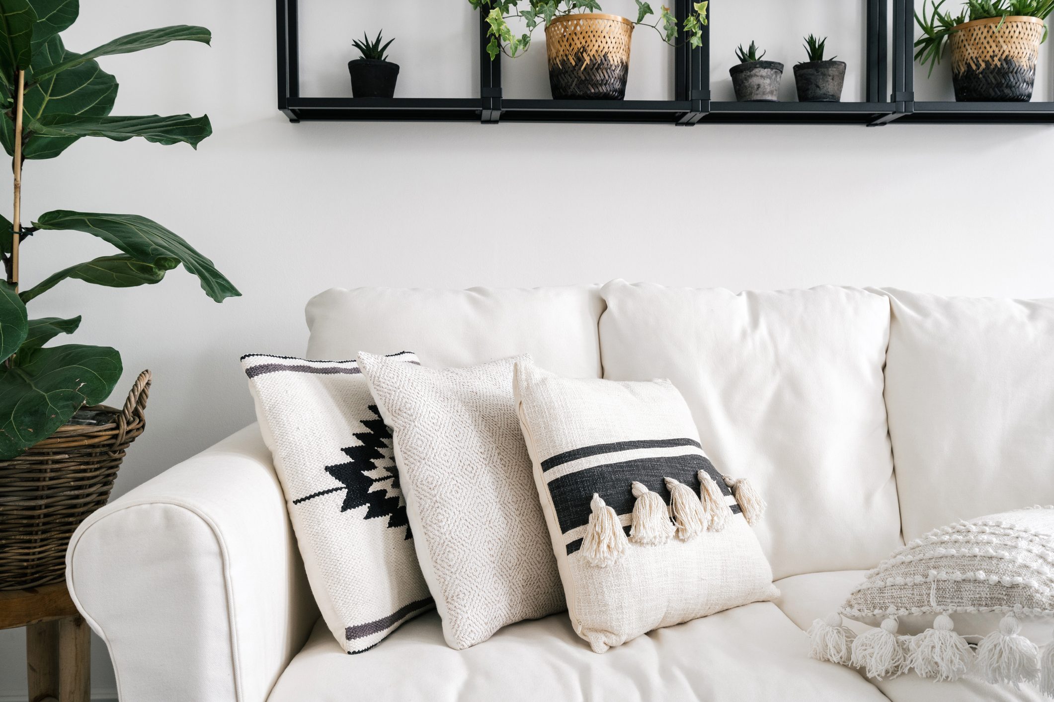 decorative pillows on white sofa in lounge room with bohemian style