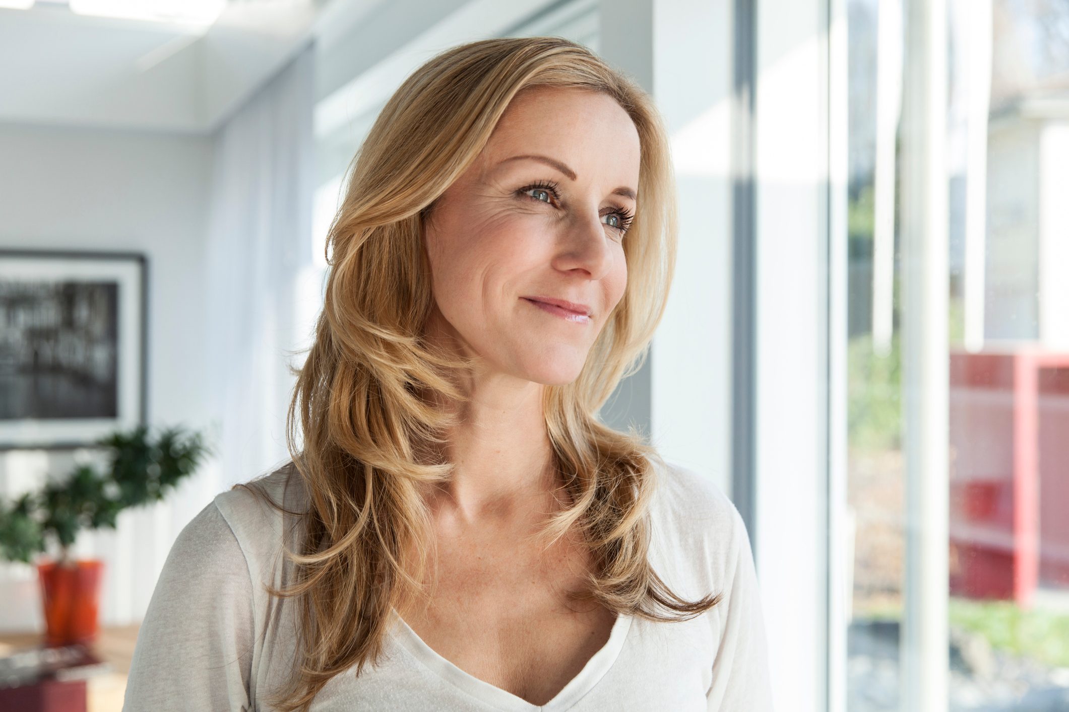 Portrait of happy woman in her bright modern home