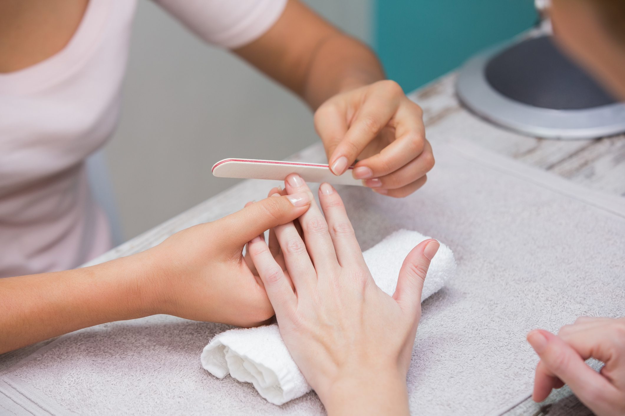 Nail technician giving manicure to customer