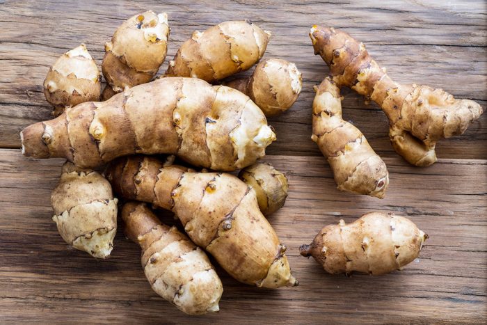 Jerusalem artichoke on wooden background.
