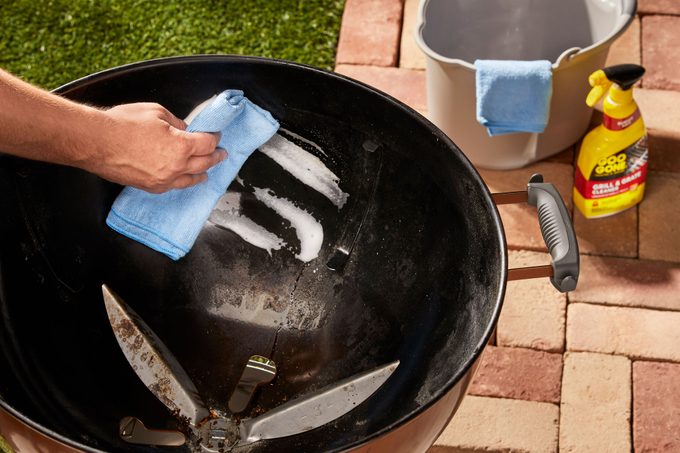 wiping interior of charcoal grill