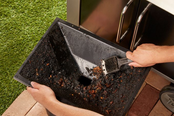 cleaning drippings pan of gas grill